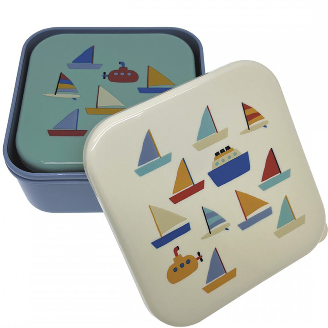 Twee maison petit jour snackdoosjes met botenpatroon, waarvan één wit doosje met open deksel over een lichtblauw doosje.
