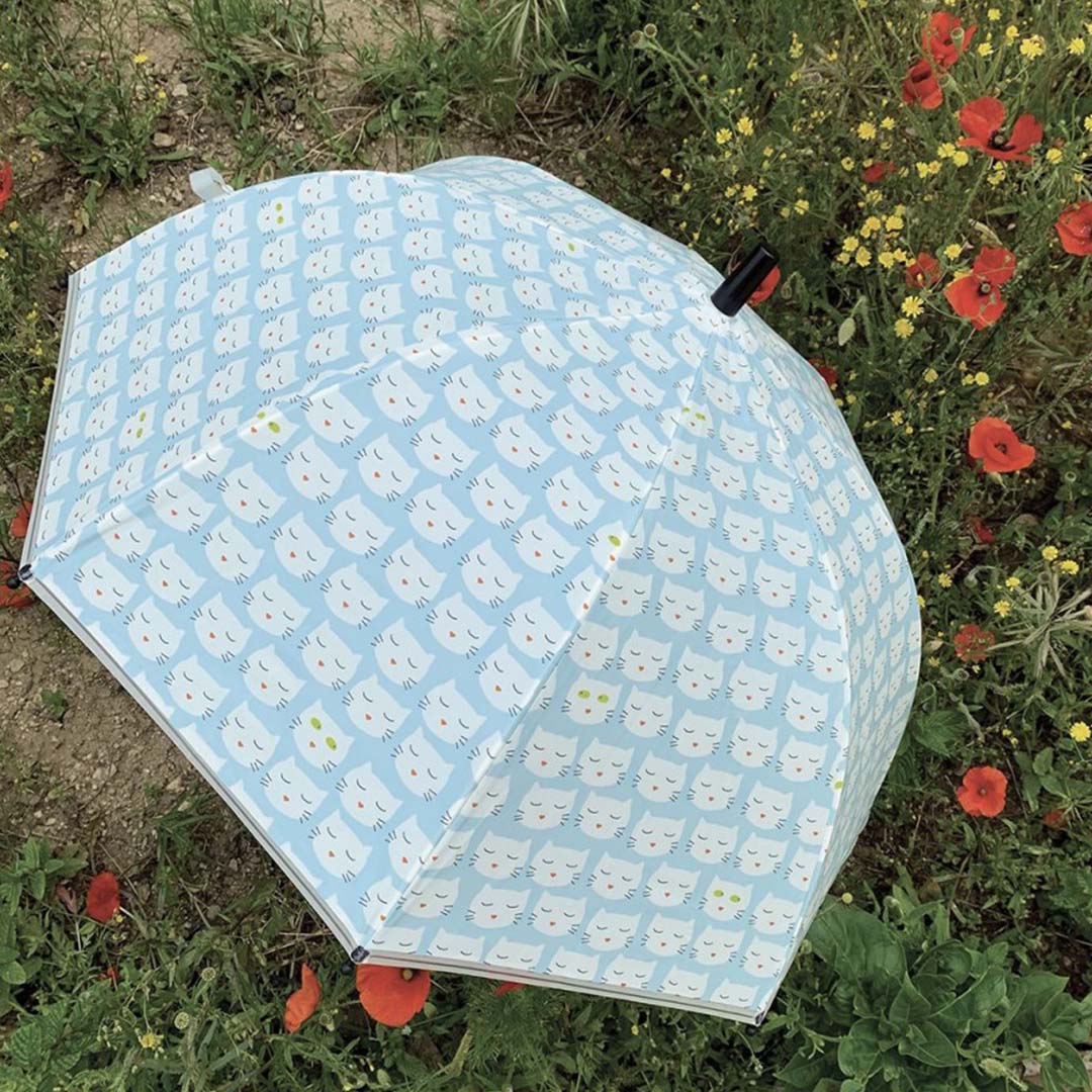 Maison petit jour kinderparaplu met kattenpatroon ligt open in een bloemenveld.