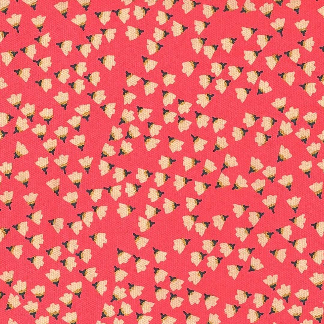 Detail van de roze stof met wit en groen bloemenpatroon van de rugzak.