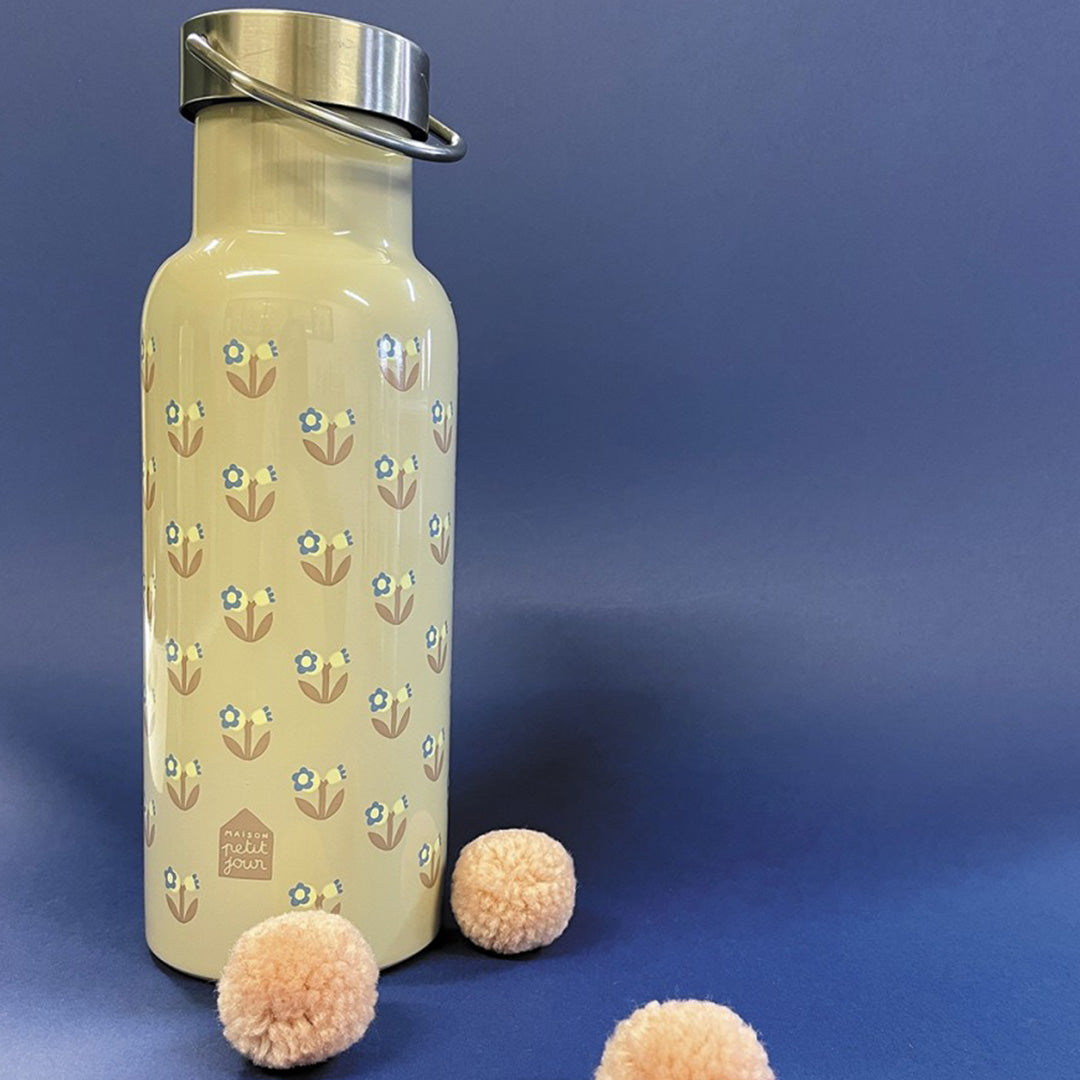 Maison petit jour beige roestvrijstalen drinkfles met bloemetjespatroon op een blauwe achtergrond met roze pompons.
