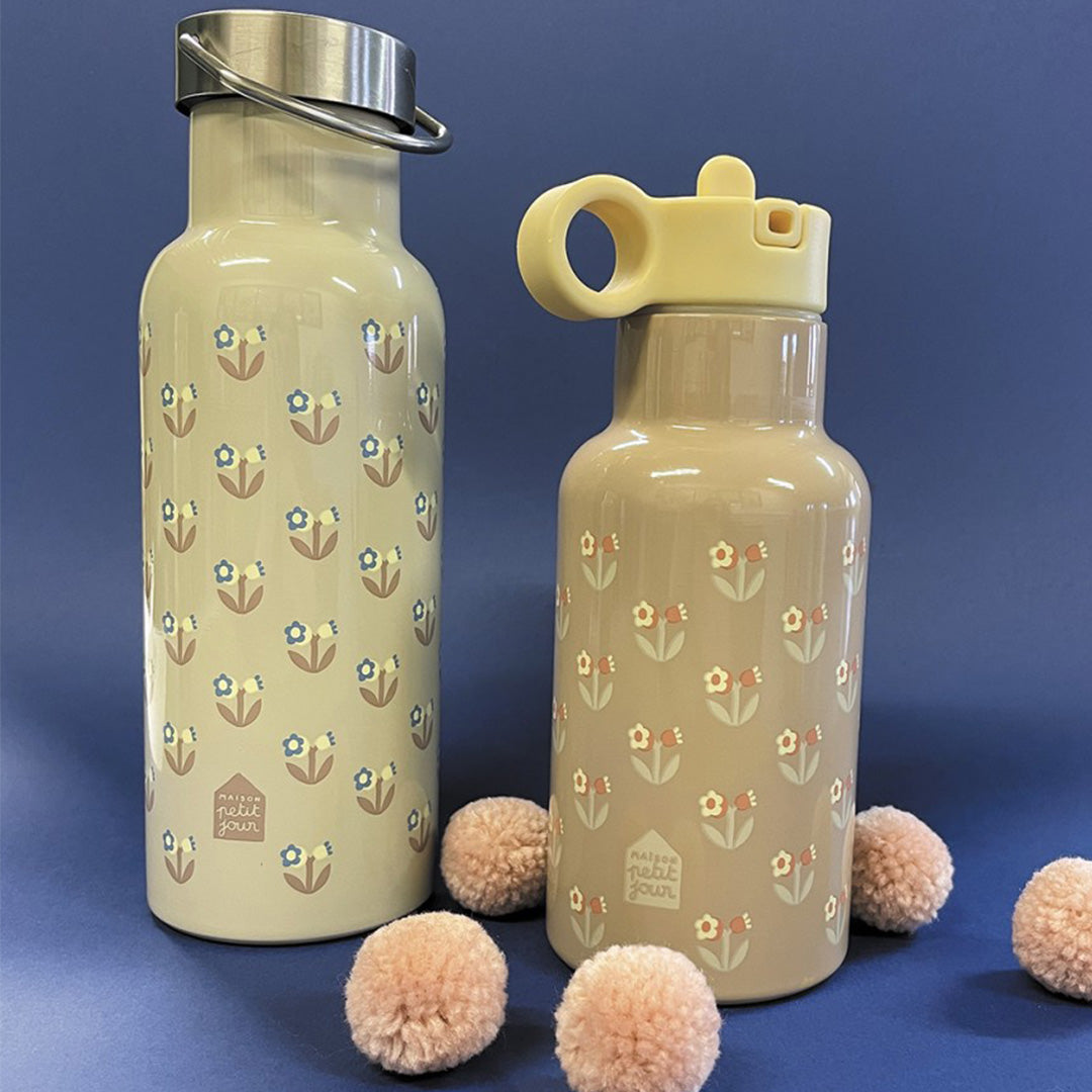 Twee maison petit jour roestvrijstalen drinkflessen met bloemetjespatroon en verschillende doppen, omringd door roze pompons.
