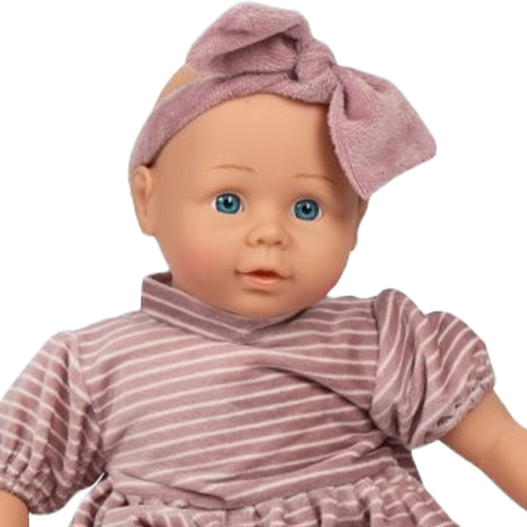 Close-up van het gezicht van mama memo babypop Sofia met blauwe ogen en een roze hoofdband.