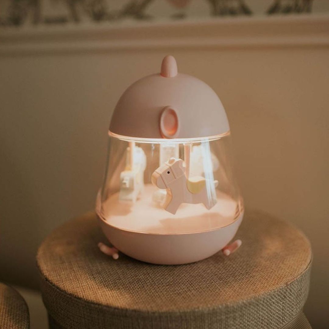 De Mary's roze muziekdoos met nachtlampje, verlicht en met een paardje zichtbaar, staand op een krukje.