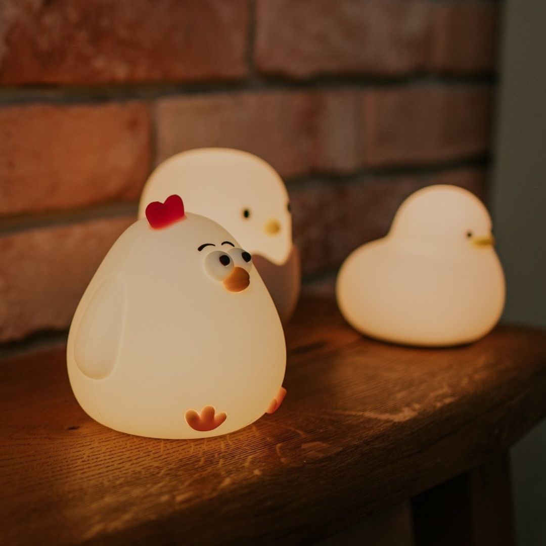 Drie Mary's kip nachtlampjes die warm licht geven op een houten plank.