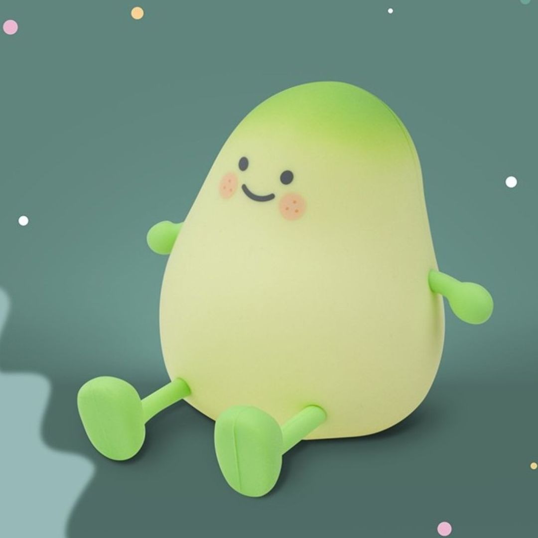 Mary's mango nachtlampje, een groen figuur met een lachend gezicht, tegen een donkergroene achtergrond met stippen.