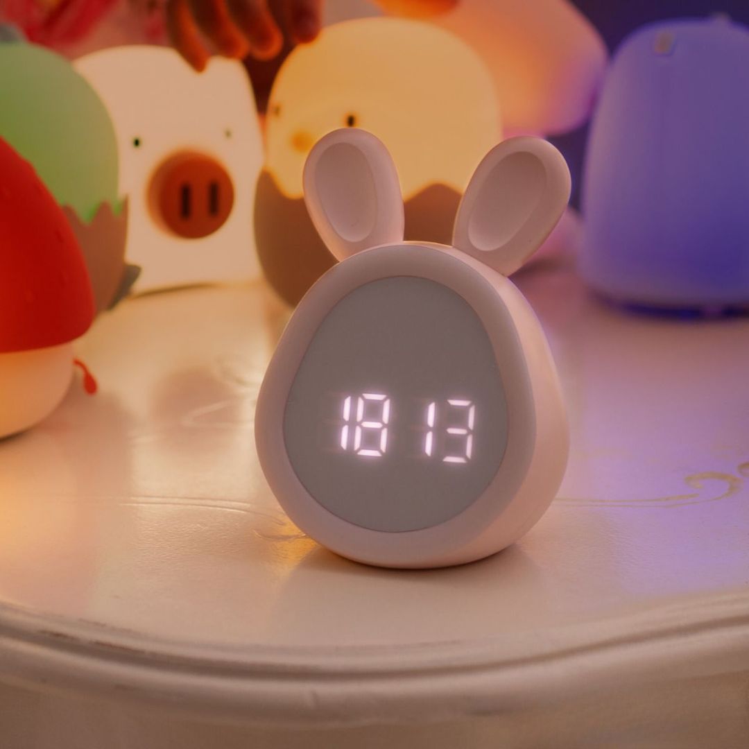 mary's roze konijn wekker en nachtlampje met digitale tijdsaanduiding op een nachtkastje.