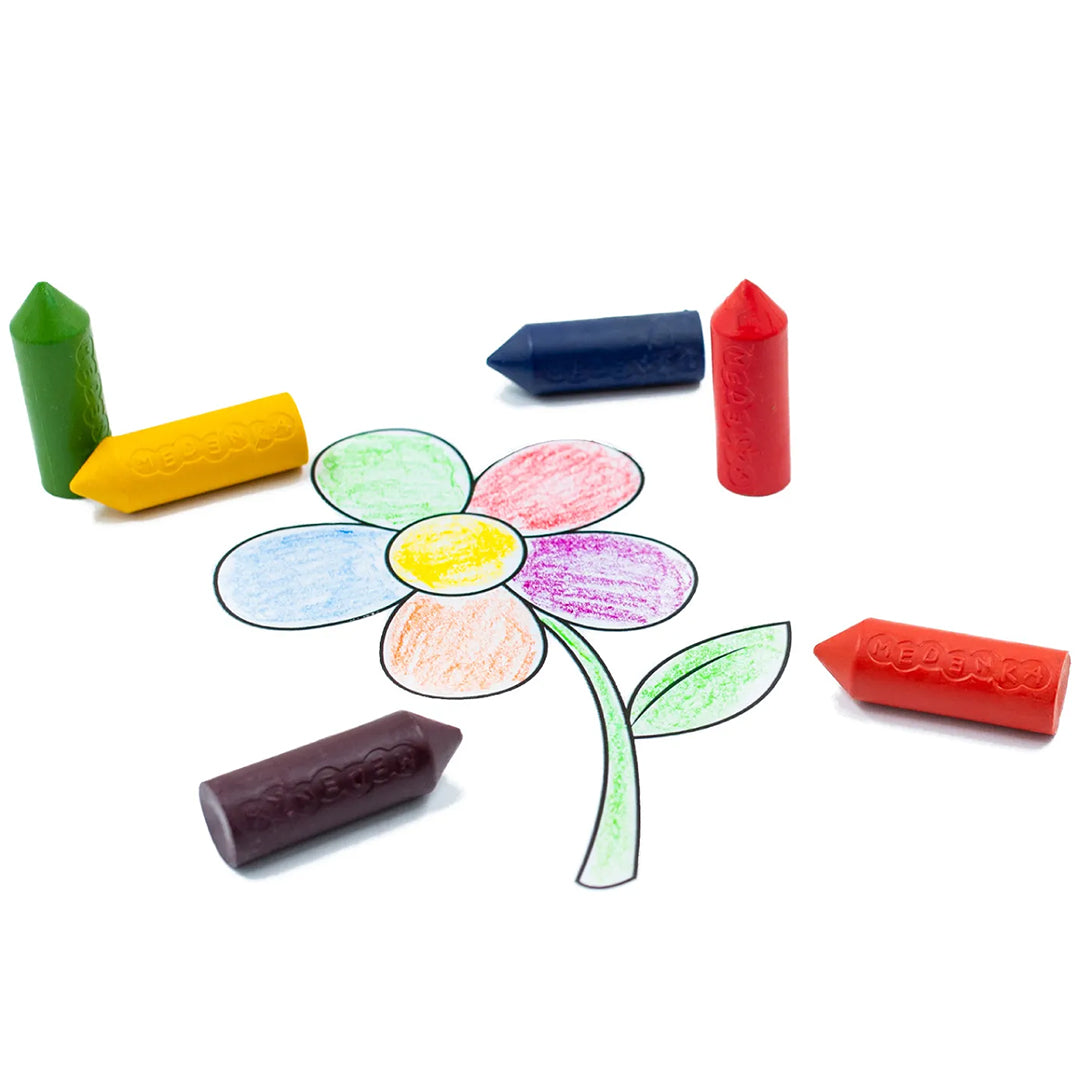 Zes Medenka bijenwaskrijtjes in verschillende kleuren liggen rondom een getekende bloem.