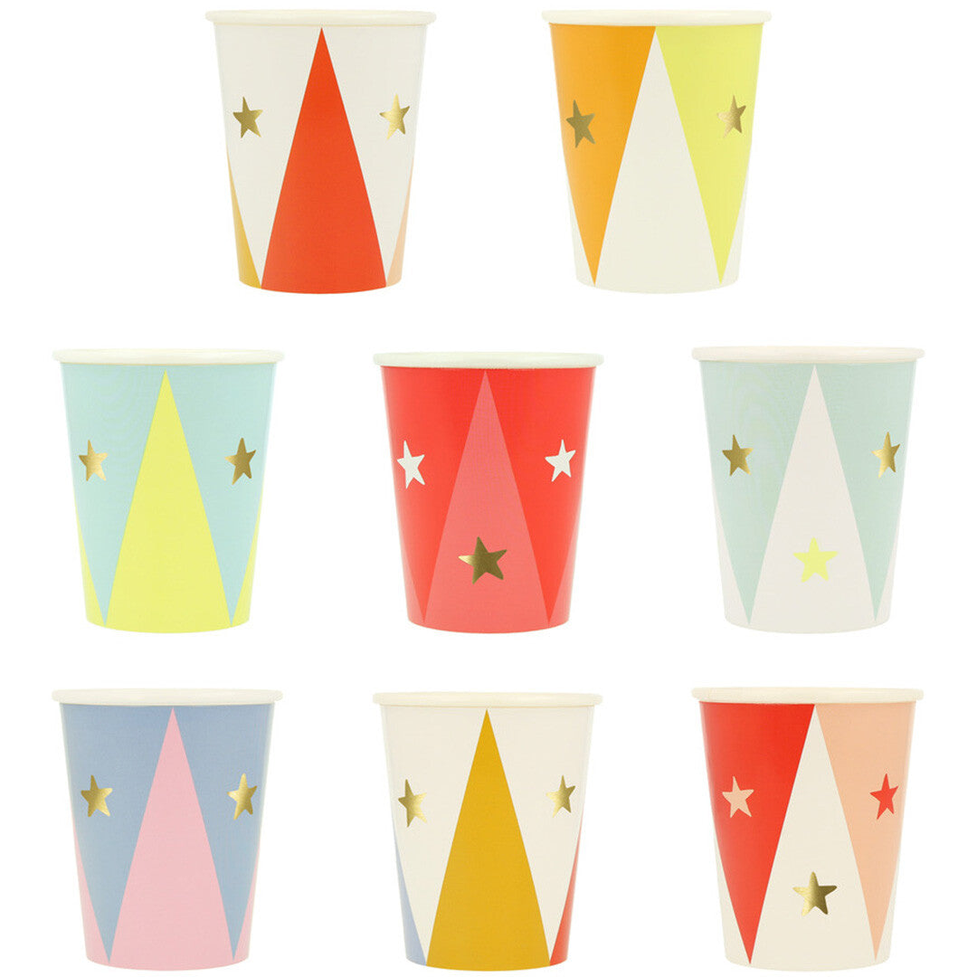 Collectie van zeven Meri Meri papieren feestbekers met circus thema, sterren en geometrische patronen in verschillende kleuren.