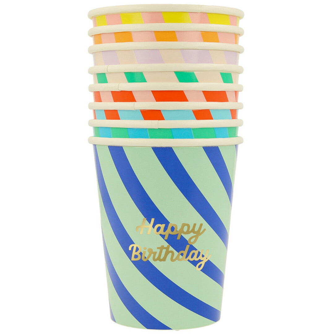 Stapel Meri Meri papieren verjaardagsbekers met diverse kleurrijke diagonale strepen en 'Happy Birthday' tekst.