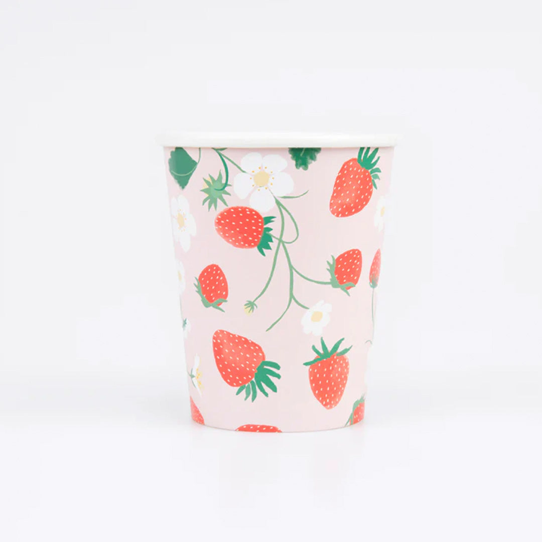 meri meri papieren feestbeker met aardbeien en bloemen op een roze achtergrond.