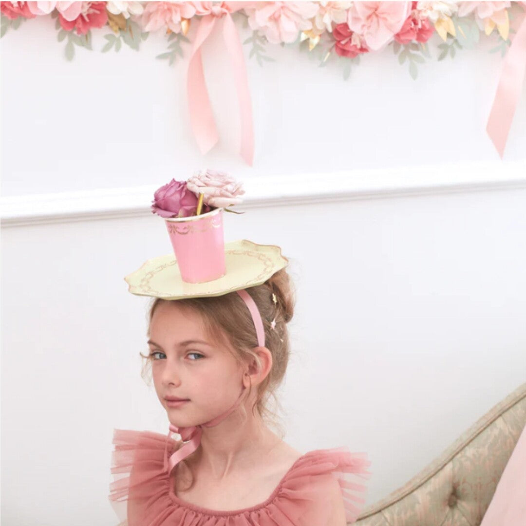 Meisje met een Meri Meri Ladurée Paris feestbordje en beker als hoedje op haar hoofd.
