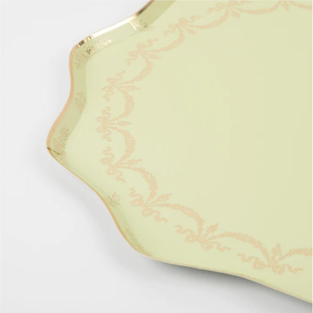 Detail van een Meri Meri groen bloemvormig feestbordje met gouden decoratie.