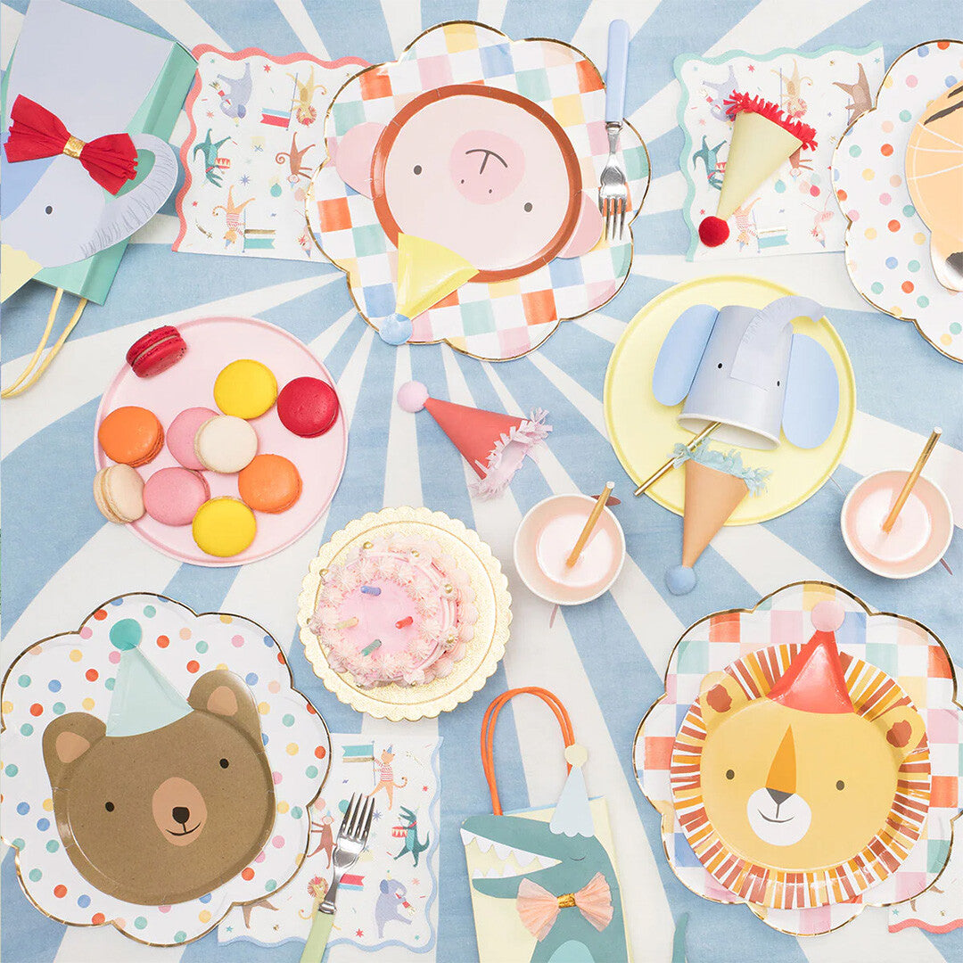 Een feestelijk gedekte tafel met diverse Meri Meri dieren thema feestartikelen, waaronder bordjes, bekers en servetten.