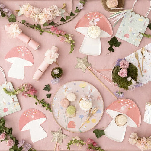 Overzicht van Meri Meri feestartikelen met feeën- en bloementhema, inclusief ronde en paddenstoelvormige bordjes, zakjes en decoraties.