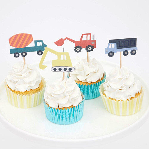 Vier cupcakes met Meri Meri bouwvoertuig toppers en gestreepte wrappers op een witte schaal.