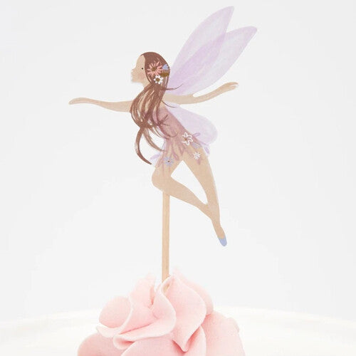 Detail van een cupcake met een feeën topper met lang bruin haar, paarse vleugels en een roze jurk.