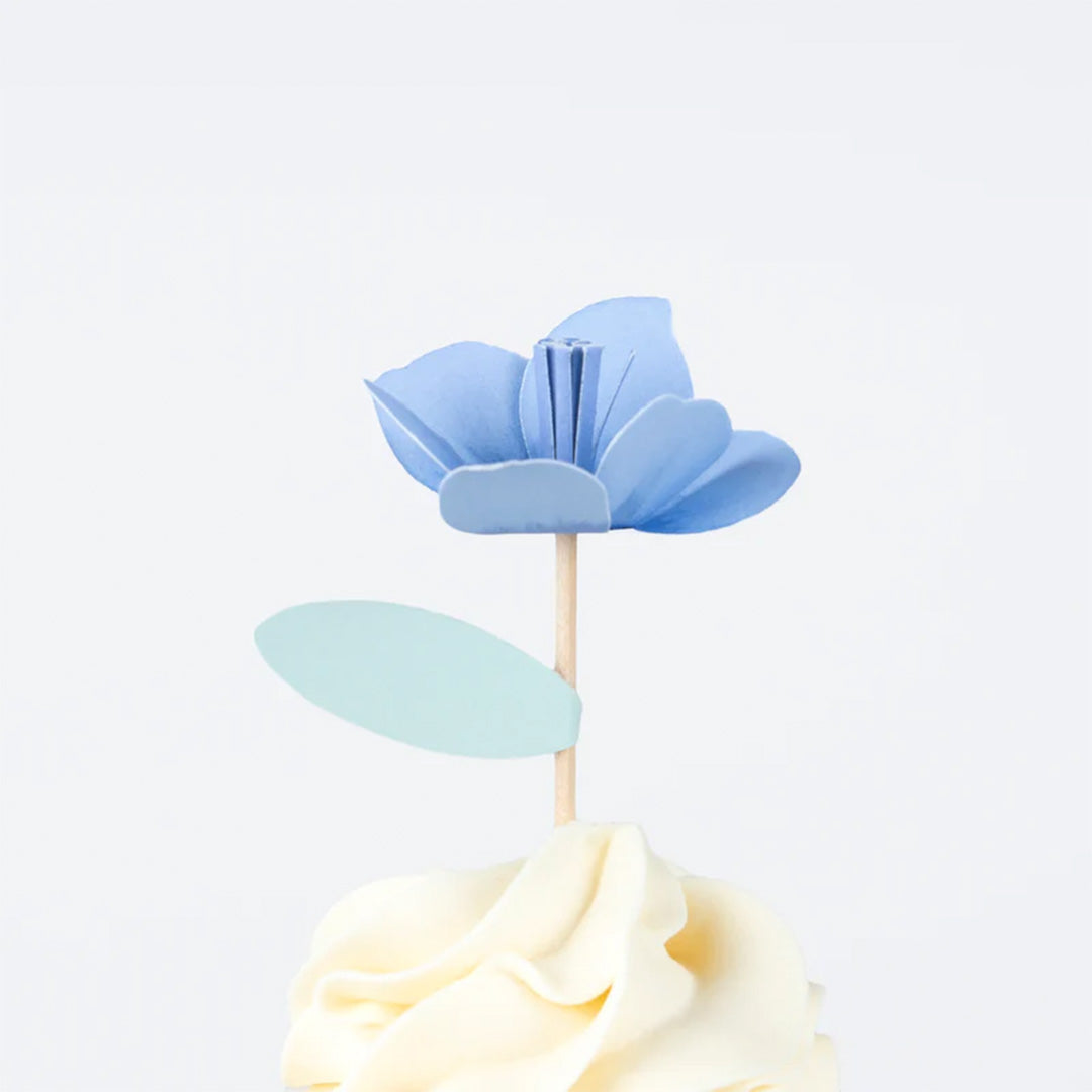 Close-up van een cupcake met een Meri Meri blauwe papieren bloem topper.