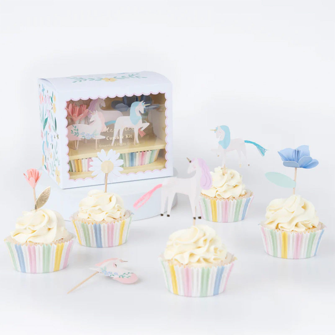 Meri Meri cupcake set met verpakking en meerdere versierde cupcakes met eenhoorn en bloem toppers.