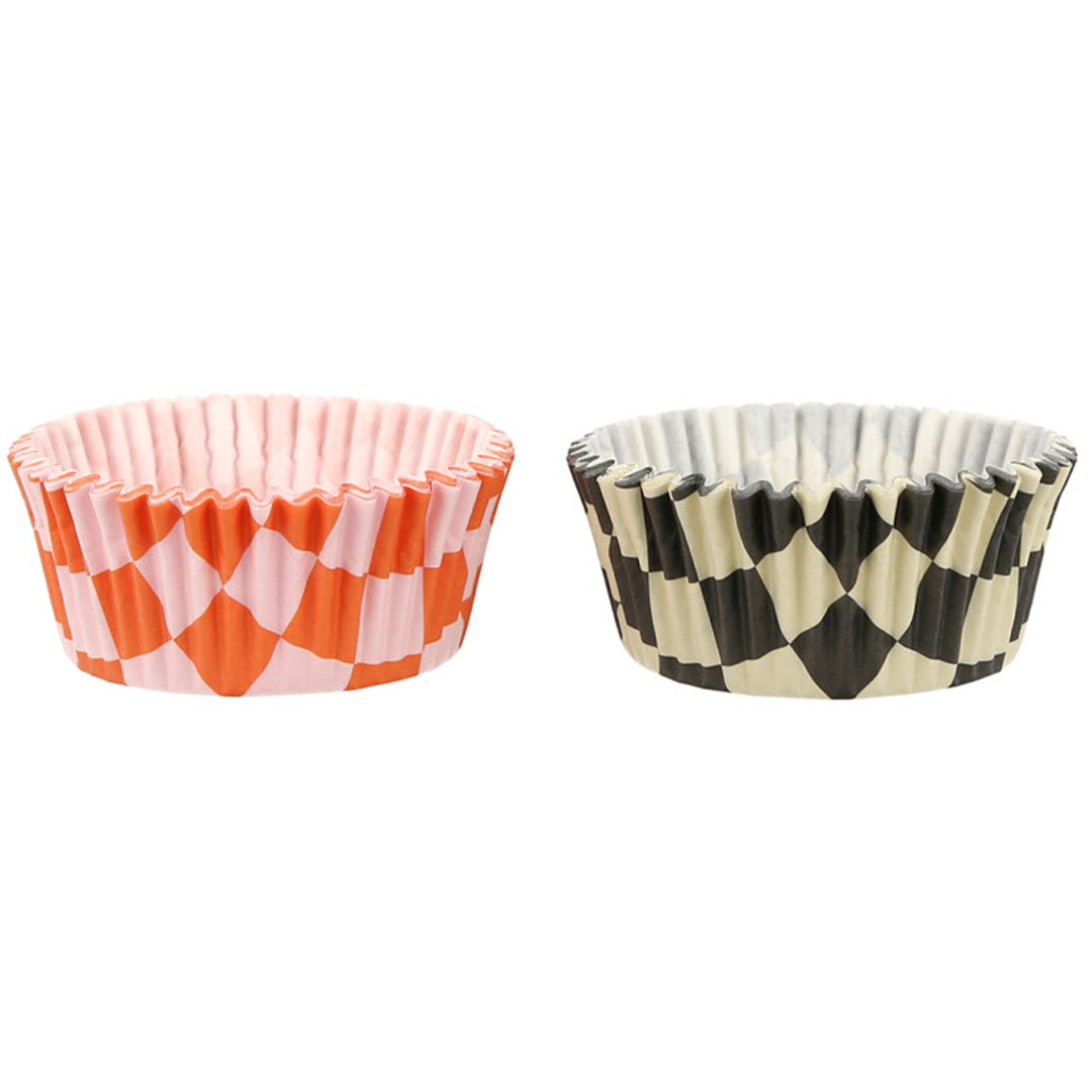 Twee stapels geruite cupcake vormpjes, één oranje-roze en één zwart-wit.