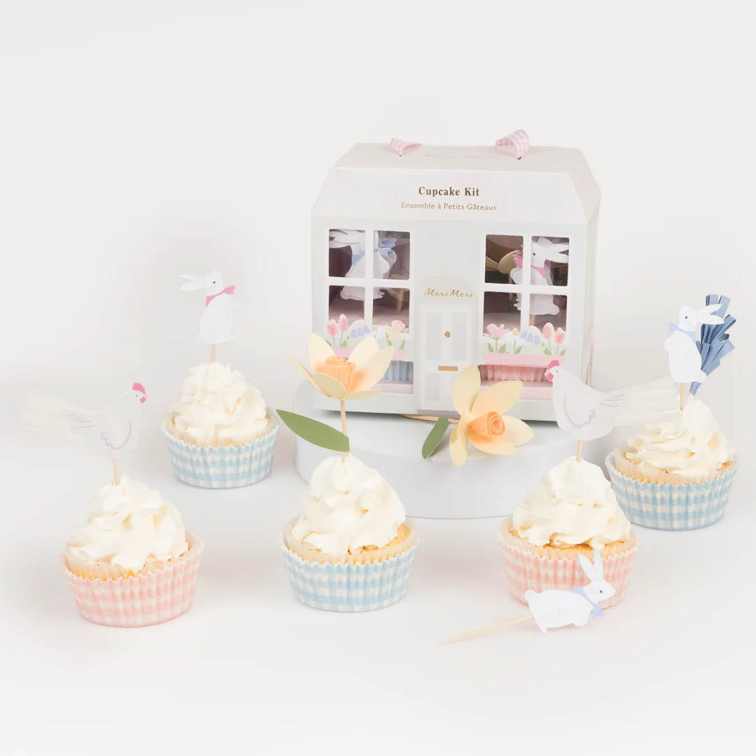 Meri Meri cupcake kit met zes versierde cupcakes en de paashuisje verpakking op de achtergrond.
