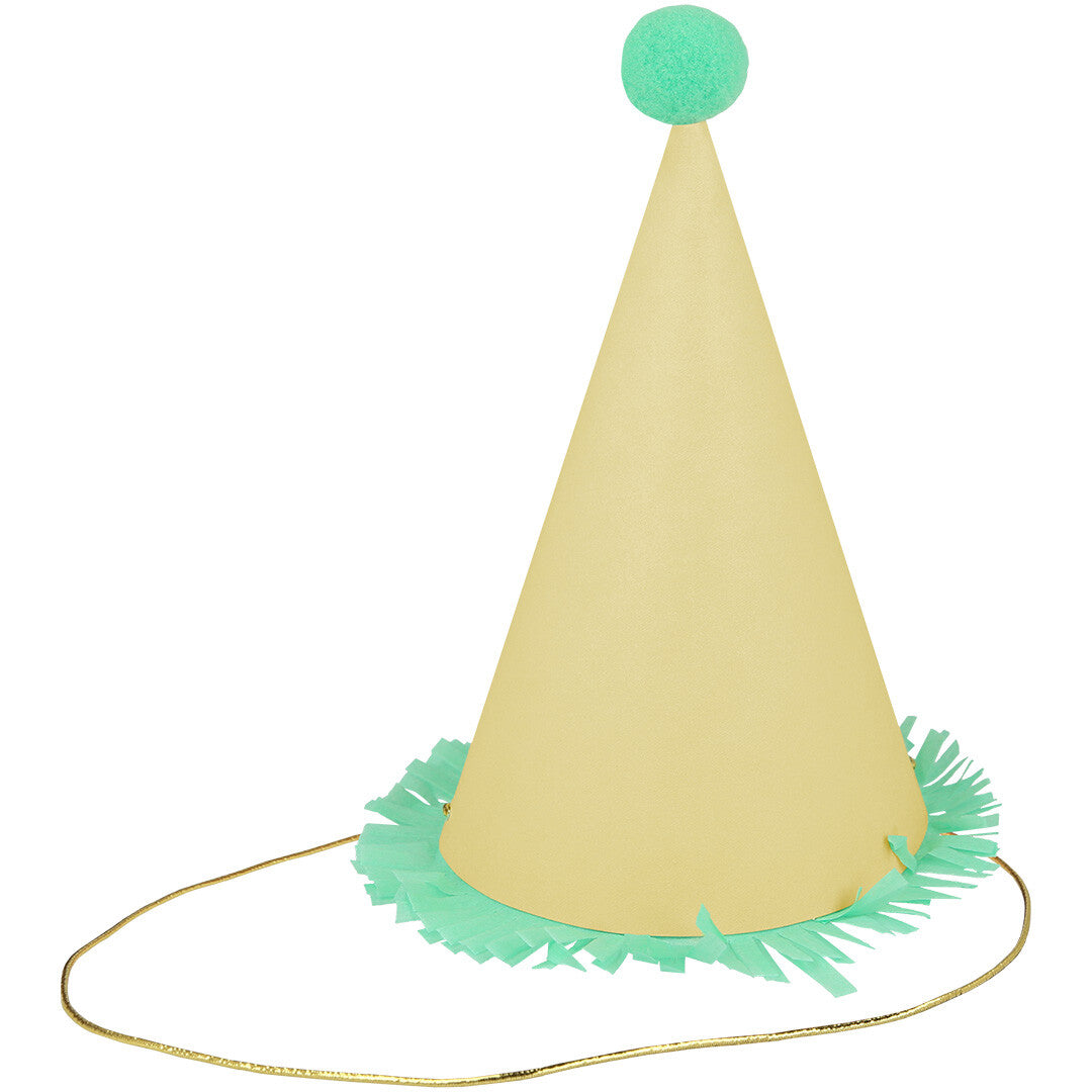Een geel feesthoedje met een groene pompon, groene franjes en een gouden elastiek.