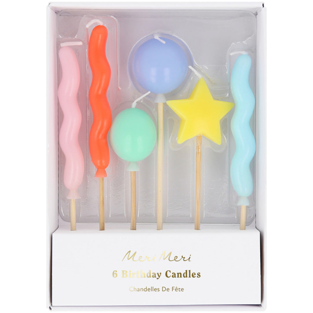 De verpakking van de Meri Meri set met zes kleurrijke verjaardagskaarsen in verschillende vormen.