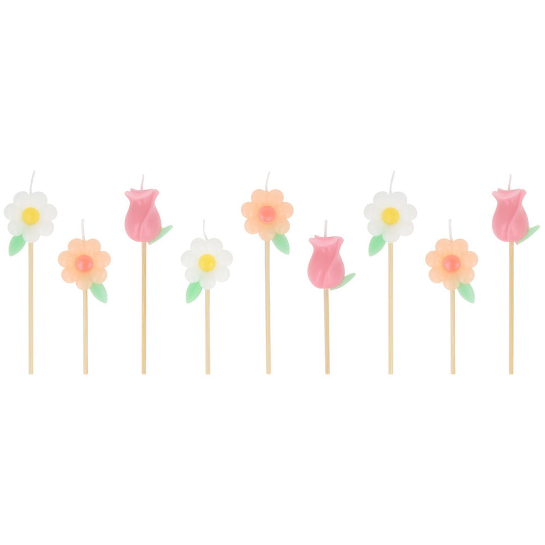 Negen Meri Meri feestkaarsjes in de vorm van witte madeliefjes, oranje bloemen en roze tulpen staan op een rij.