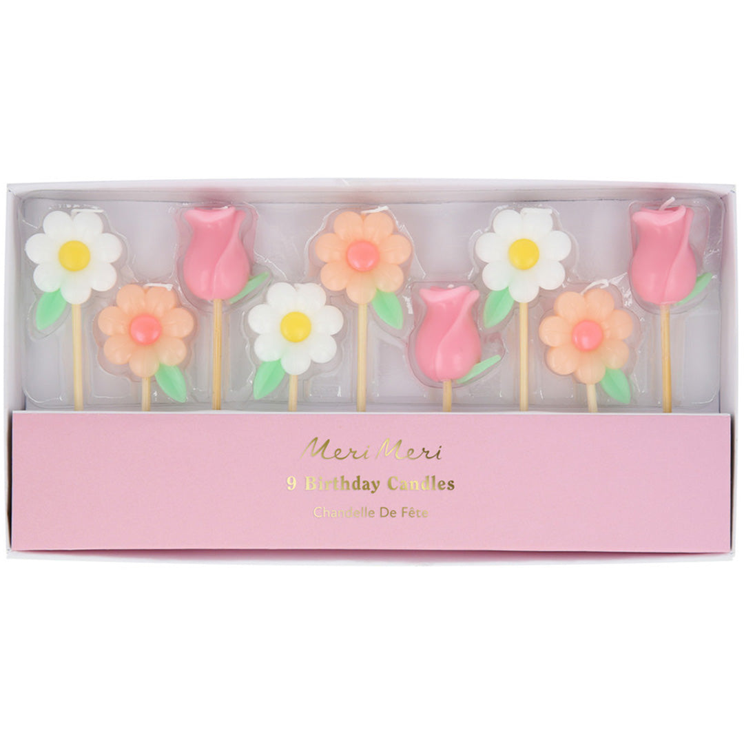 De verpakking van de Meri Meri feestkaarsjes met negen bloemkaarsjes zichtbaar door een venster.