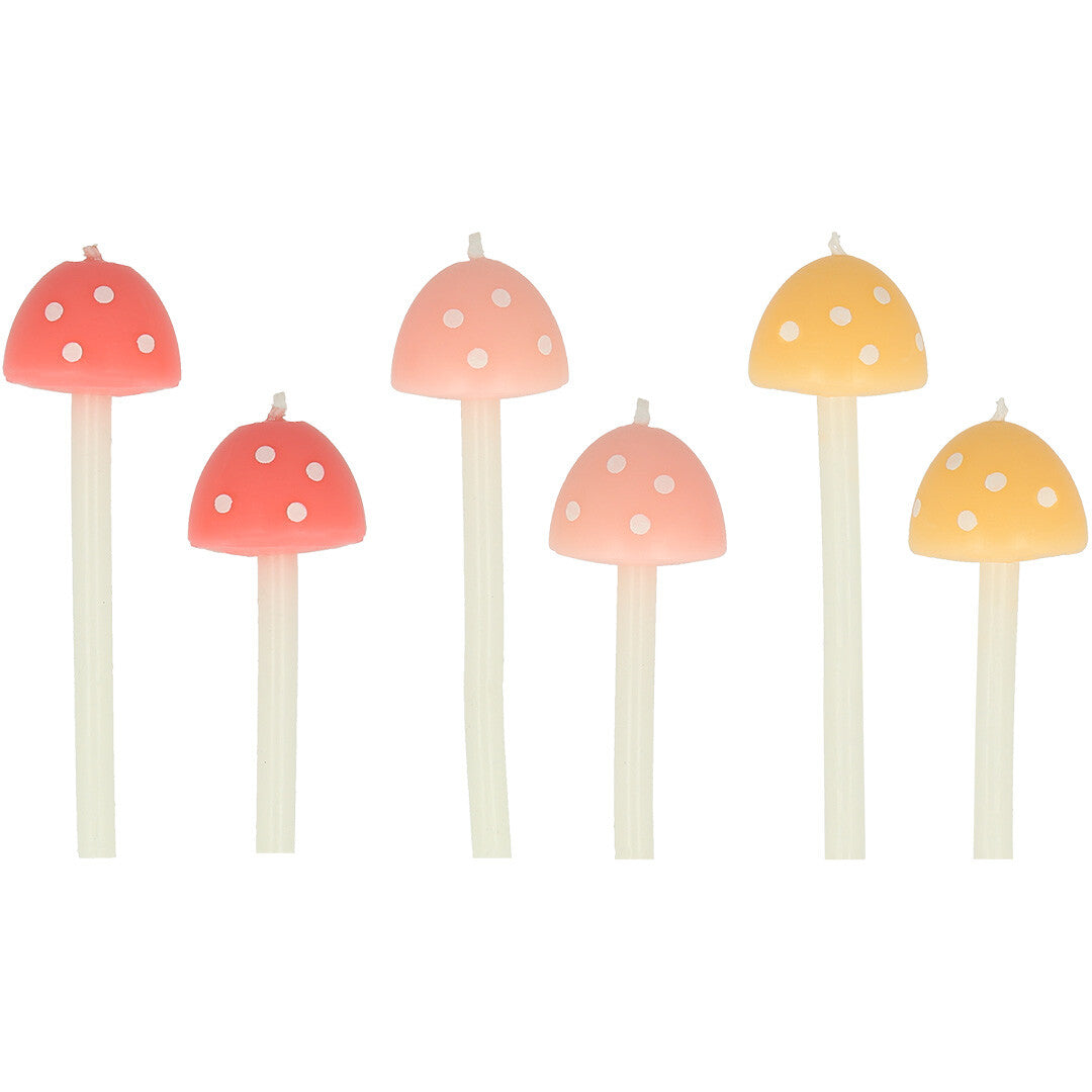 Zes Meri Meri paddenstoel verjaardagskaarsen in roze en gele kleuren met witte stippen.