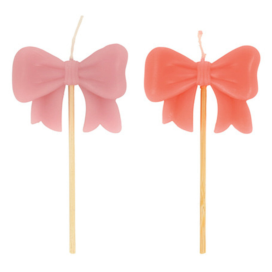 Twee roze en koraalkleurige strikjes verjaardagskaarsen.