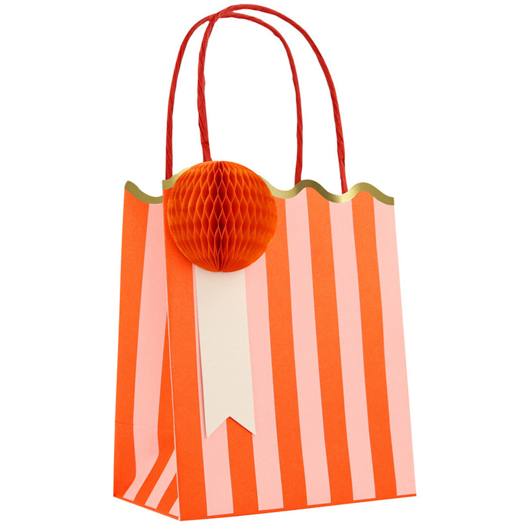 Een Meri Meri gestreept feesttasje in oranje met een oranje honingraatdecoratie.