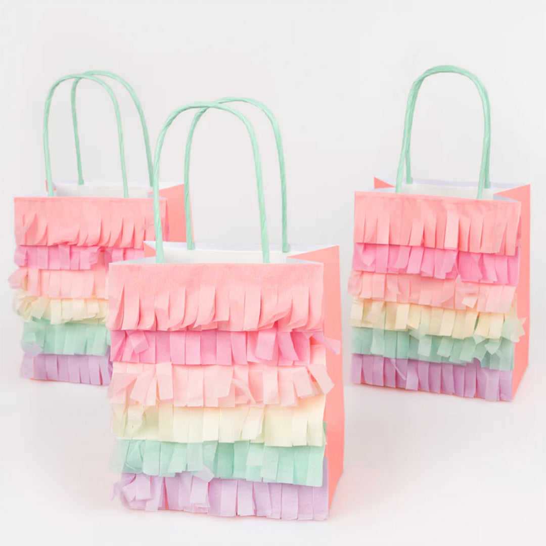 Drie Meri Meri feesttasjes met pastelkleurige regenboogfranjes, schuin op een rij.