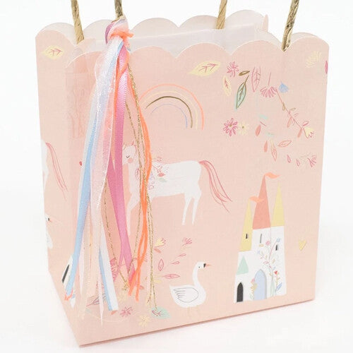 Meri Meri roze papieren cadeautasje met eenhoorn, kasteel, zwaan en regenboogpatroon, schuin van voren gezien.