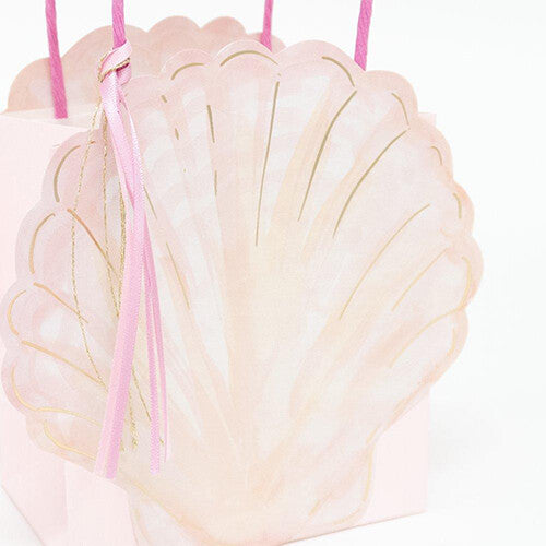 Detail van een Meri Meri roze schelpvormig feesttasje met gouden accenten en roze kwastje.
