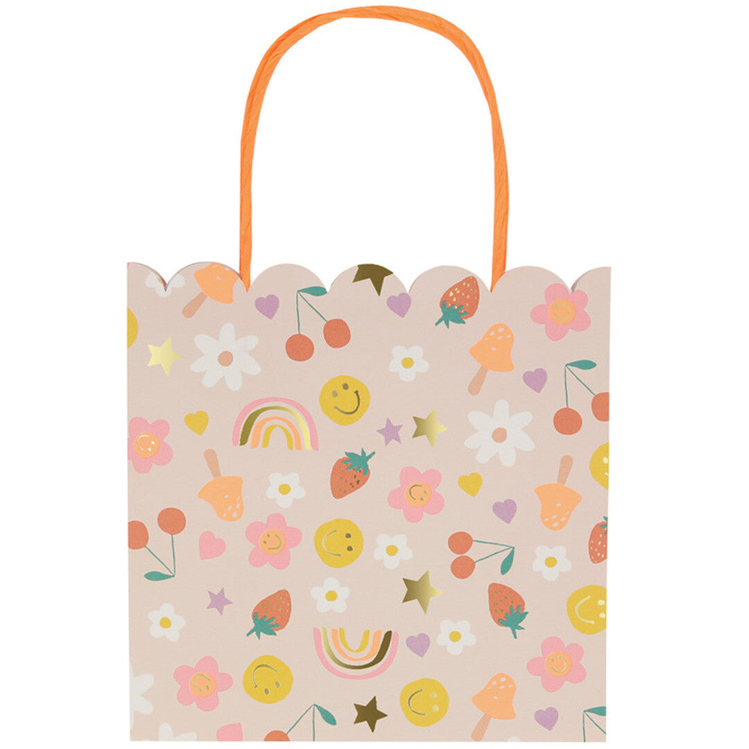 Vooraanzicht van een Meri Meri roze cadeautasje met vrolijke figuurtjes en oranje hengsels.