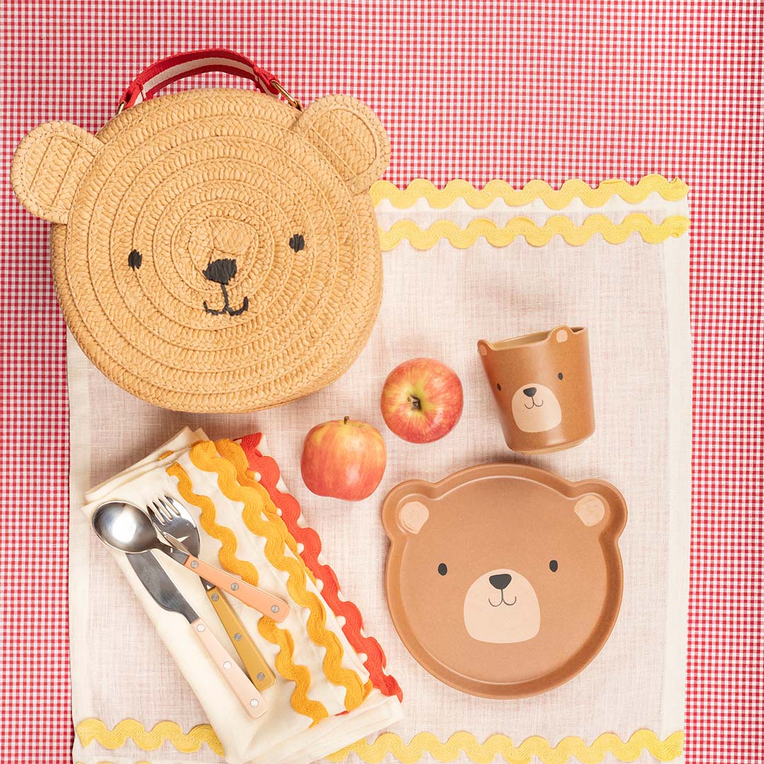 Meri Meri kinderhandtas in beervorm op een picknickkleed met bijpassend servies en twee appels.