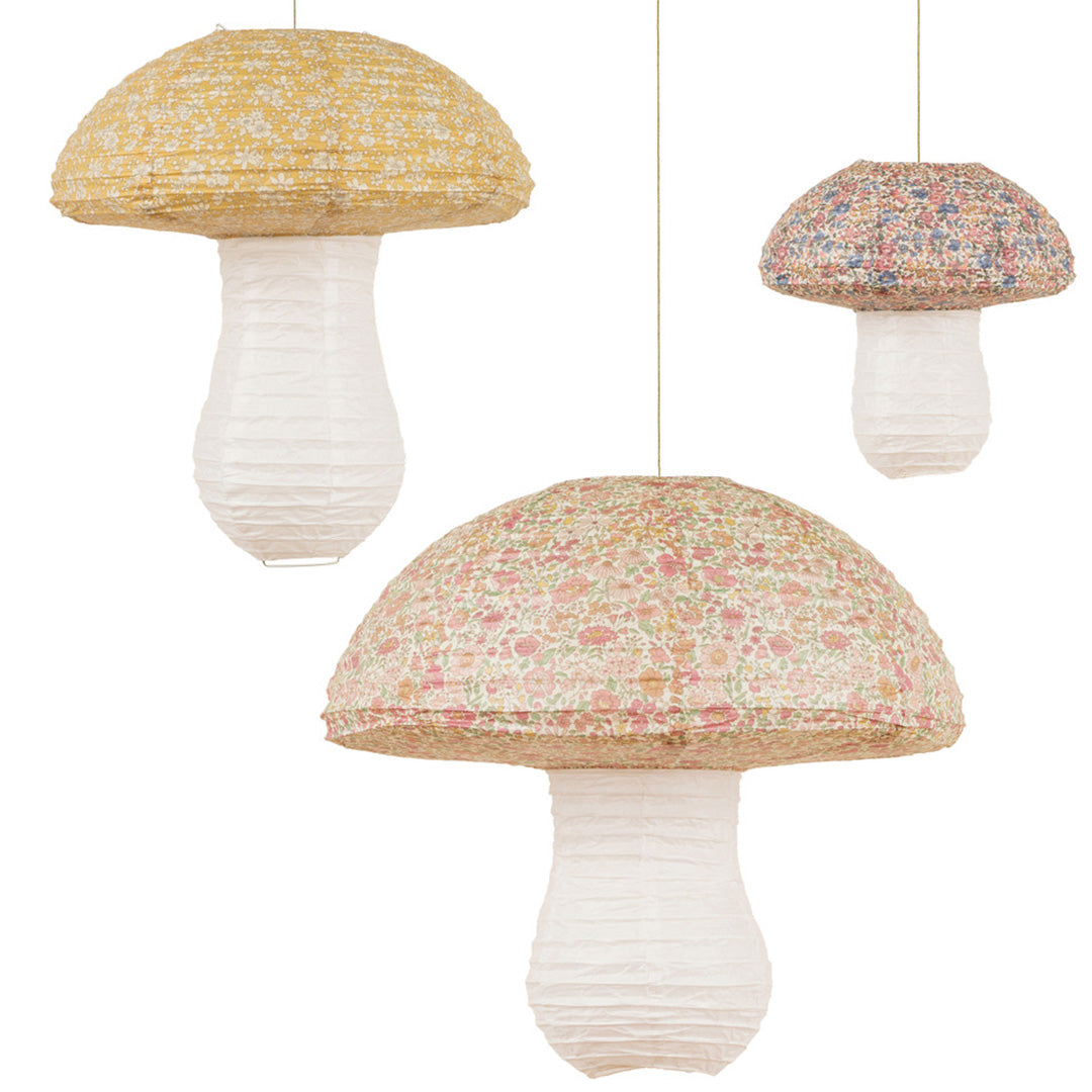Drie Meri Meri paddenstoel lampionnen met gebloemde patronen hangen tegen een witte achtergrond.