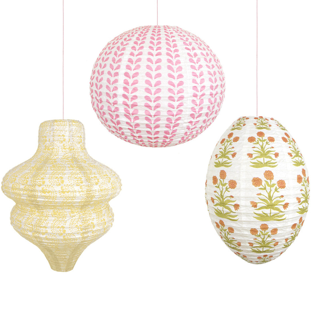 Drie Meri Meri papieren lampionnen in verschillende vormen en met gebloemde patronen hangen naast elkaar.