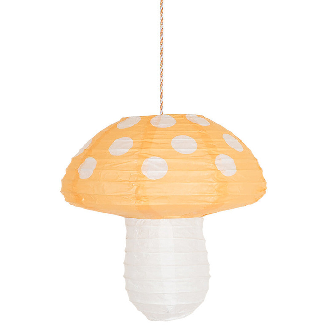Een gele Meri Meri papieren paddenstoel lampion met witte stippen hangt aan een touwtje.