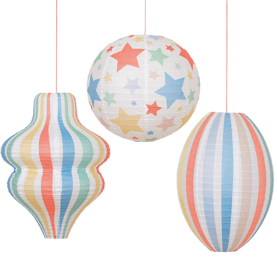 Drie veelkleurige meri meri papieren lampionnen met sterren en strepen in verschillende vormen.