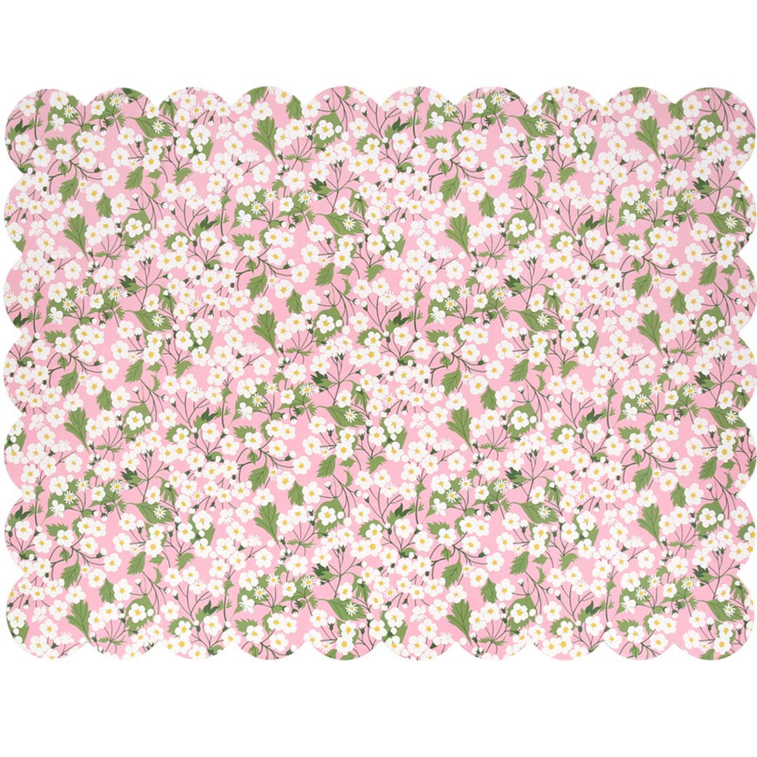 Meri Meri roze placemat met wit bloemenpatroon en geschulpte rand, van bovenaf gefotografeerd.