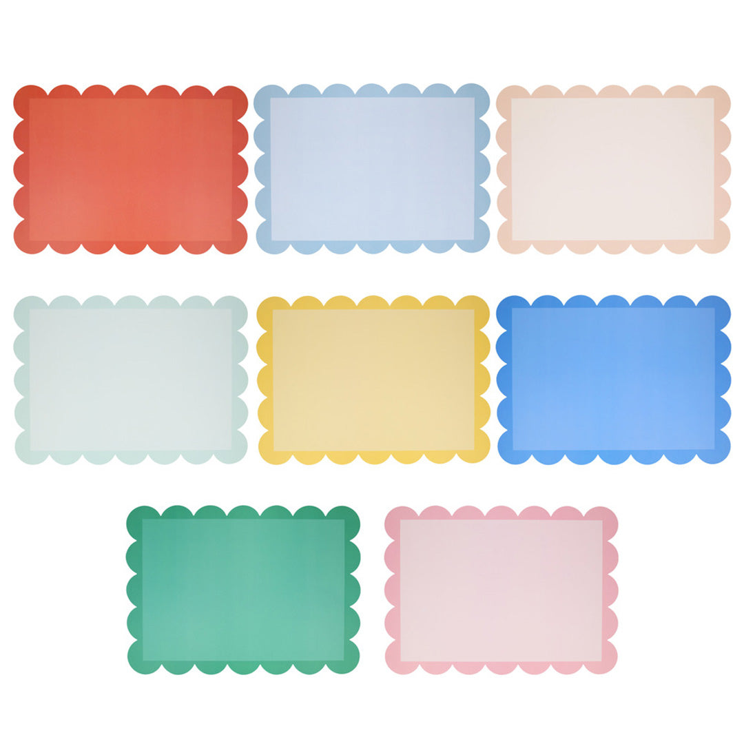 Zeven meri meri placemats in verschillende pastelkleuren met een geschulpte rand, individueel weergegeven.