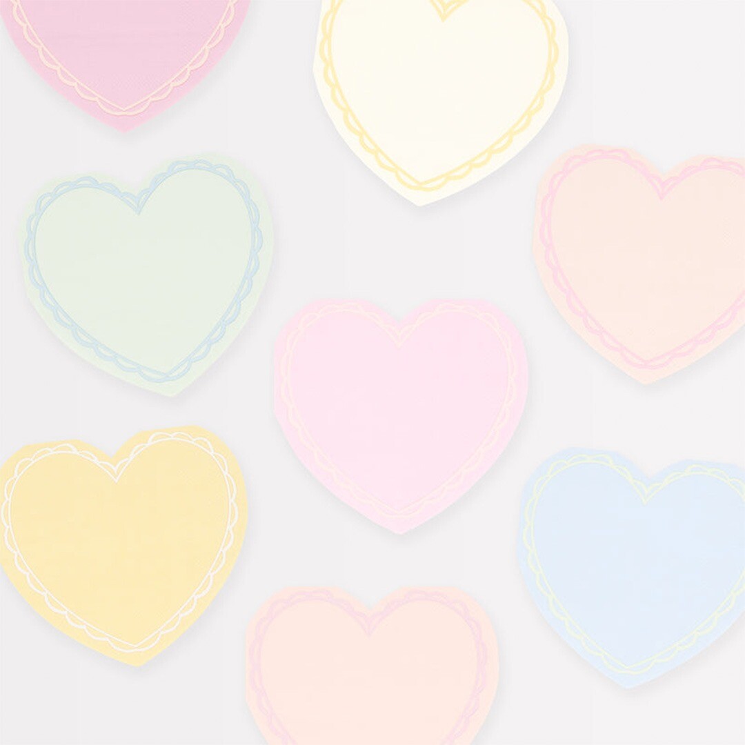 Meerdere Meri Meri hartjes cocktailservetten in pastelkleuren verspreid over een lichte ondergrond.