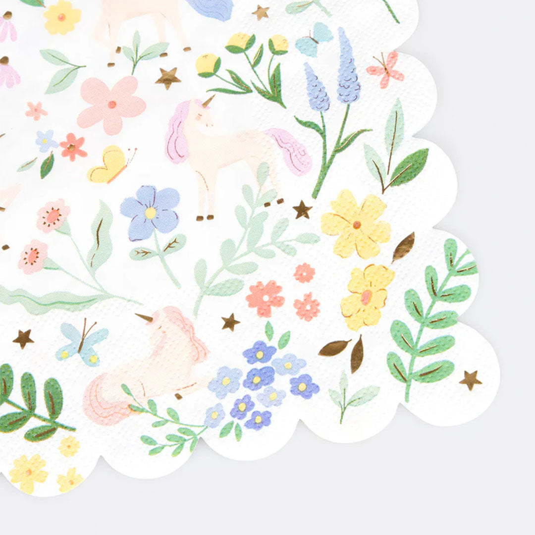 Detail van een servet met een patroon van eenhoorns, bloemen en bladeren.