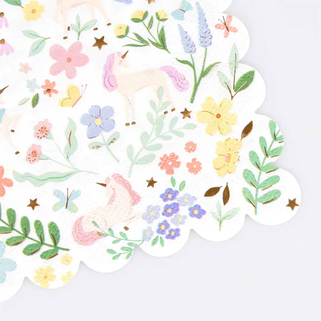 Detail van een Meri Meri servet met eenhoorns, bloemen en bladeren, met een geschulpte rand.