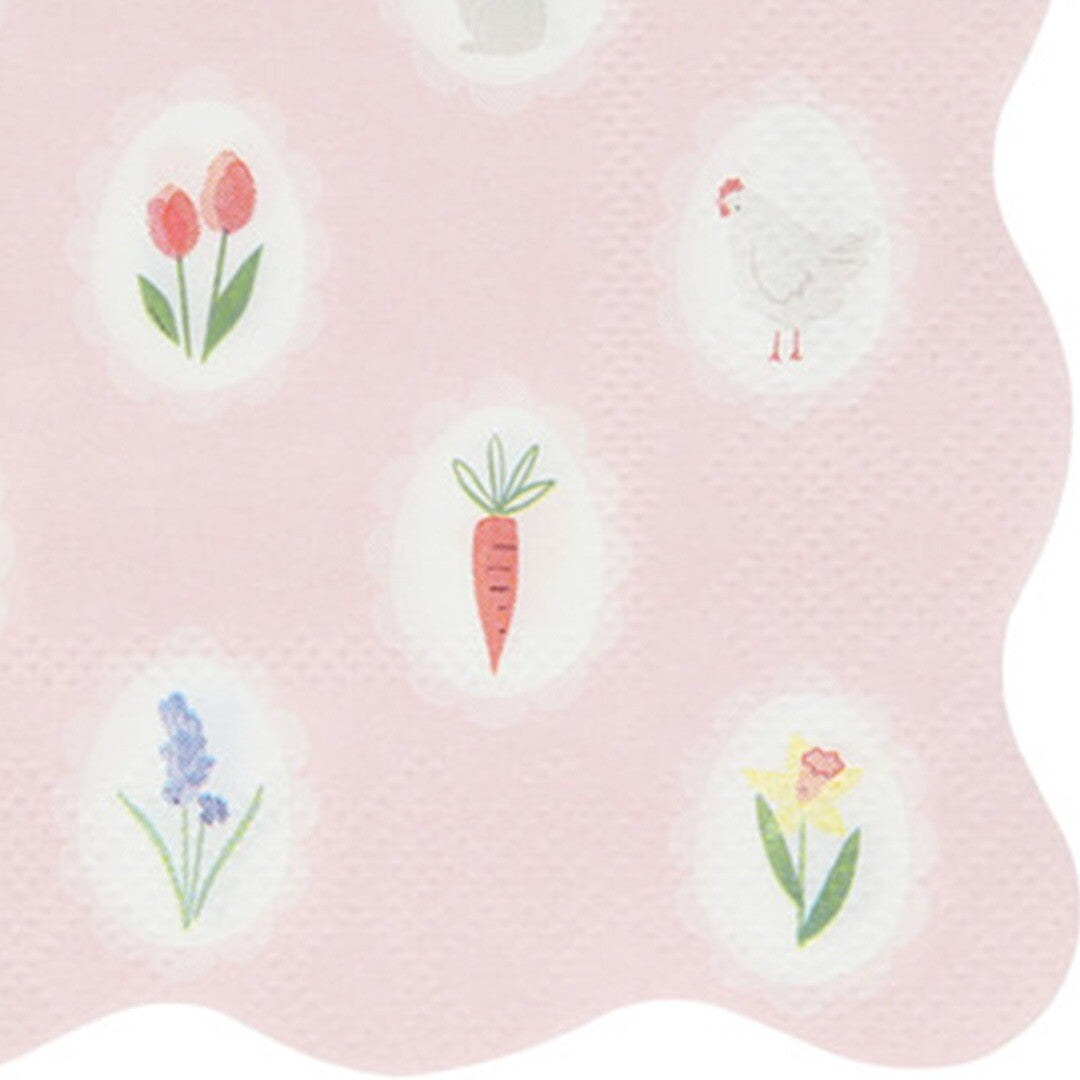 Detail van een Meri Meri paasservet met roze achtergrond en illustraties van bloemen, een kip en een wortel in ovale kaders.