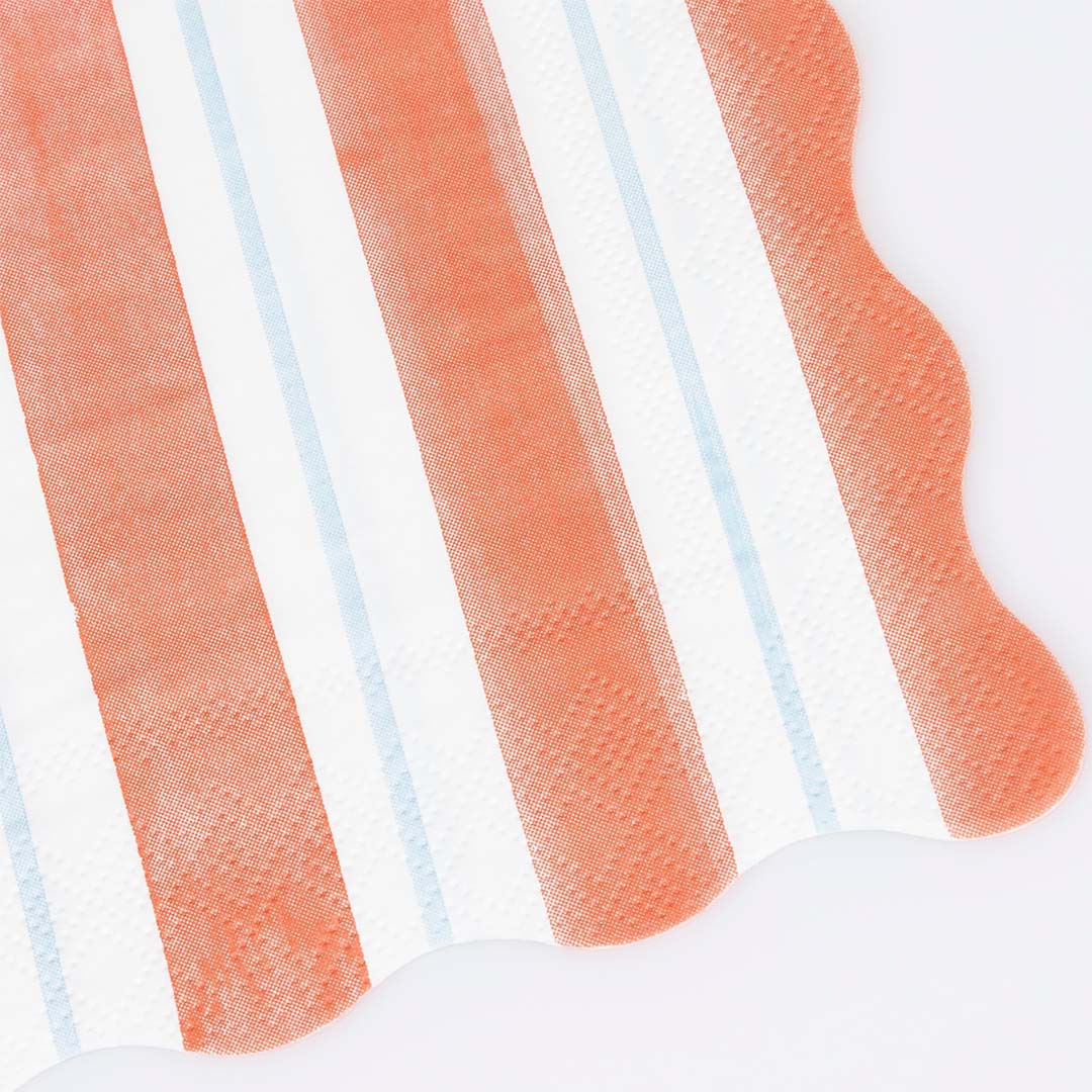 Detail van een oranje en wit gestreept Meri Meri servet met lichtblauwe accentstrepen en geschulpte rand.