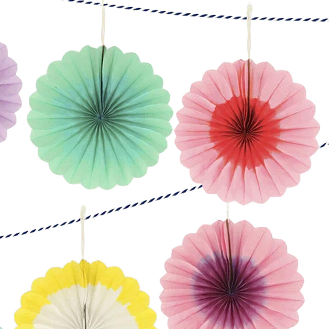 Detail van de Meri Meri slinger met vier kleurrijke papieren waaiers.