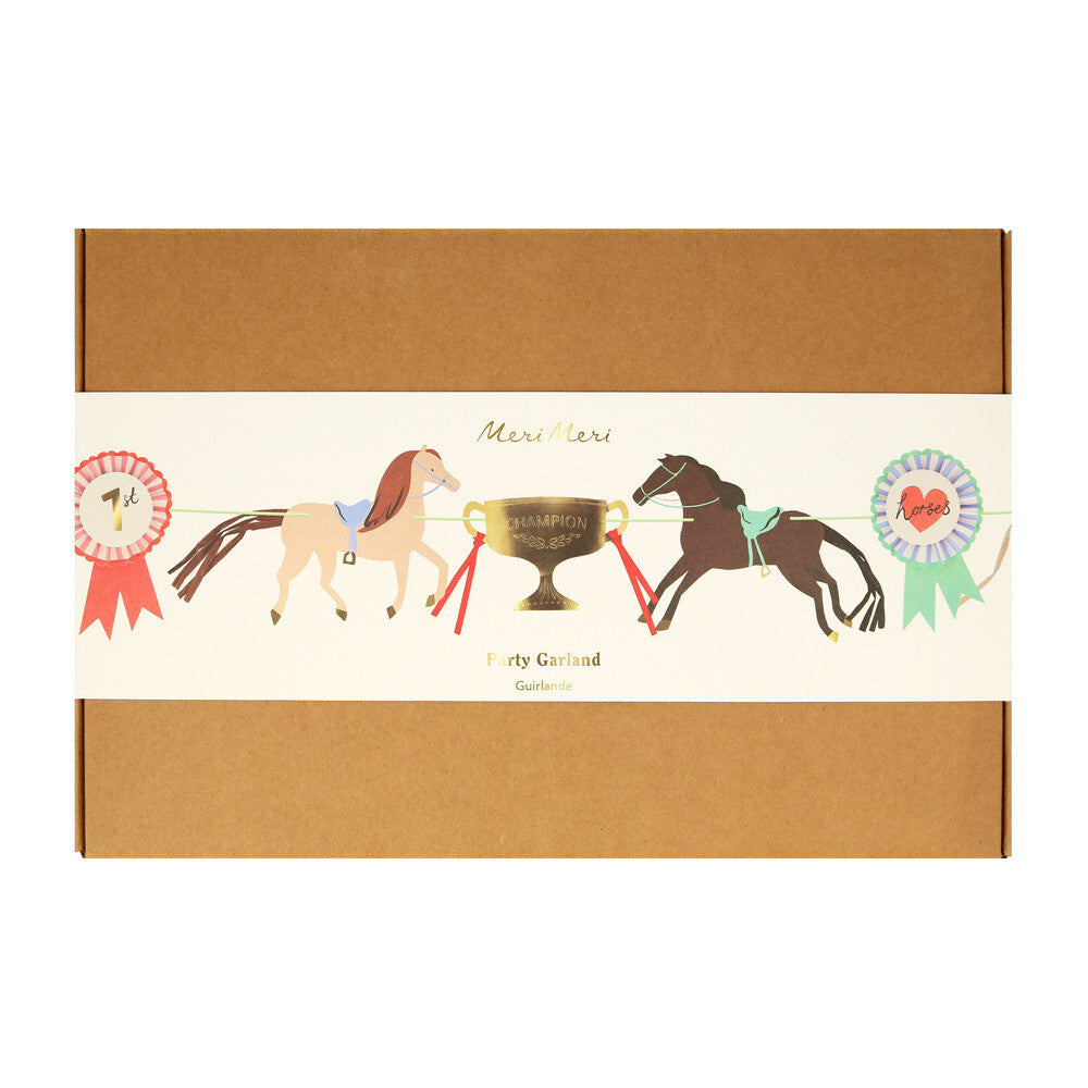 Verpakking van de Meri Meri paardenslinger, een bruine doos met een band met paarden en prijzen.