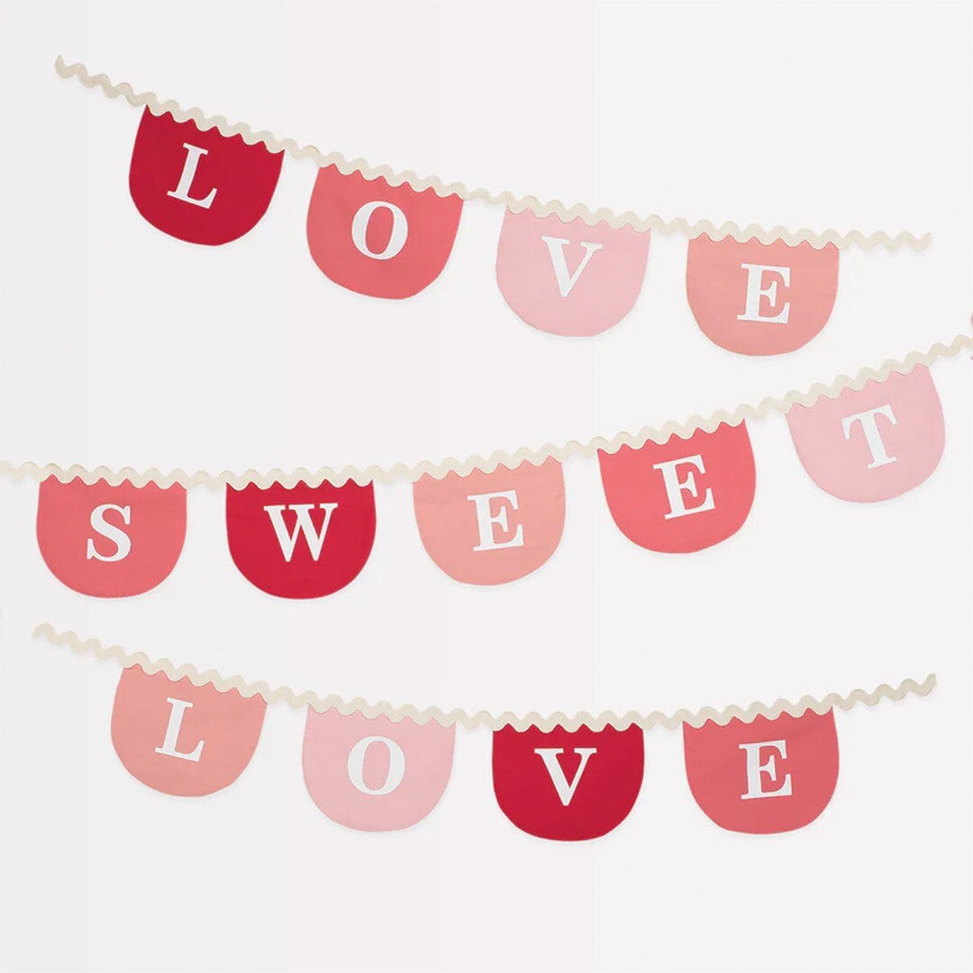 Detail van de Valentijn slinger met de tekst 'Love Sweet Love' op roze en rode vlaggetjes.
